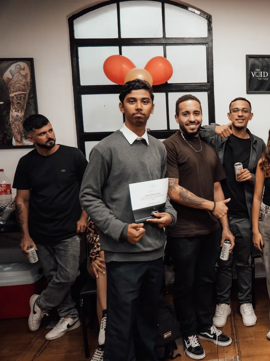 Aluno da The VOID segurando seu certificado na formatura